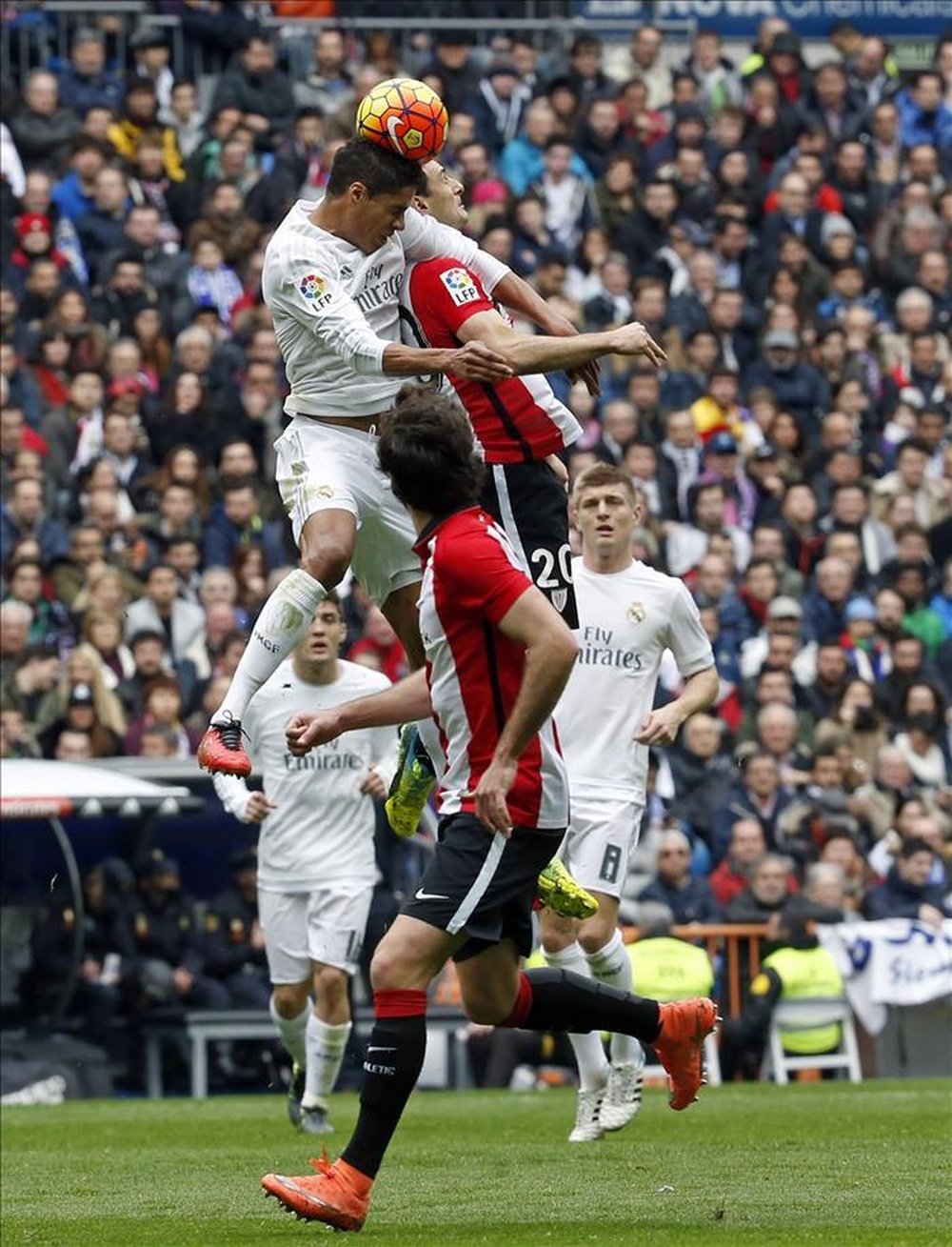 El defensa francés del Real Madrid Raphael Varane (i) pelea un balón con el delantero del Athletic Club Aritz Aduriz, durante el partido de la vigésima cuarta jornada de liga en Primera División que se disputó en el estadio Santiago Bernabéu. EFE
