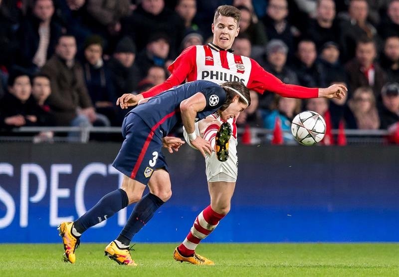 El jugador del PSV Marco van Ginkel (d) disputa el balón con Filipe Luis (i), del Atlético de Madrid,  durante un partido entre el PSV Eindhoven y el Atlético de Madrid por los octavos de final de la Liga de Campeones, en Eindhoven (Holanda). EFE