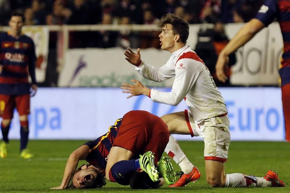El defensa del Rayo Vallecano Diego Llorente (d) comete falta sobre el croata Iván Rakitic, del FC Barcelona, durante el partido de la vigésimo séptima jornada de Liga en Primera División que se disputó en el estadio de Vallecas, en Madrid. EFE