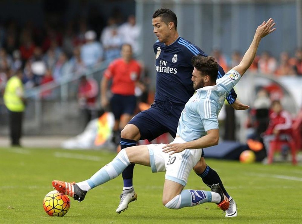 El delantero portugués del Real Madrid Cristiano Ronaldo (i) pelea un balón con el defensa del Celta Sergi Gómez, en el estadio de Balaídos. EFE/Archivo