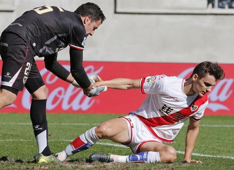 El portero del Rayo Vallecano, Toño (i), ayuda a levantarse a su compañero el defensa Diego Llorente (d), durante un partido. EFE/Archivo