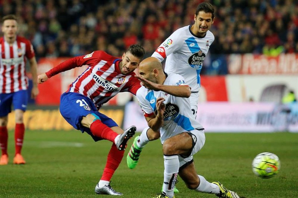 El centrocampista belga del At. de Madrid, Yannick Ferreira-Carrasco (i), golpea el balón ante el defensa del Deportivo de la Coruña, Manuel Pablo (c), durante el encuentro correspondiente a la jornada 29 de primera división, que disputaron en el estadio Vicente Calderón, en Madrid. EFE