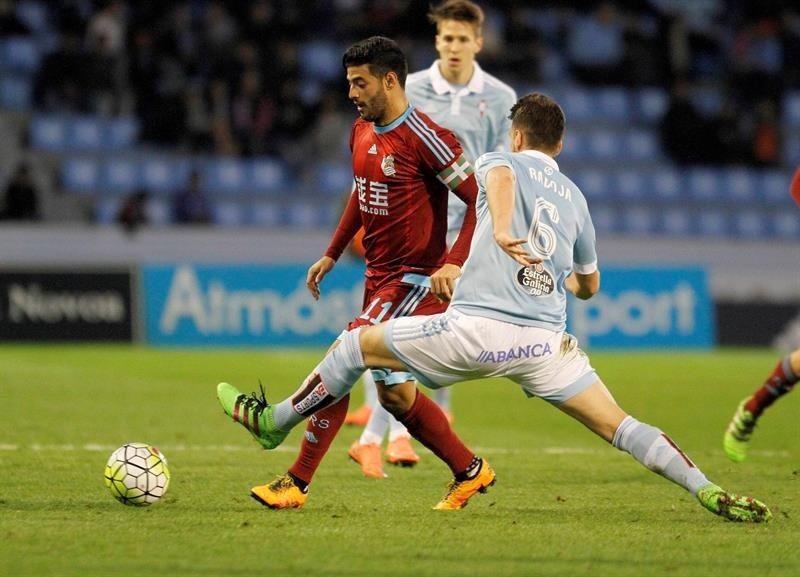 El centrocampista del Celta de Vigo Nemanja Radoja (d) pelea un balón con el delantero de la Real Sociedad Carlos Vela (c) durante el partido correspondiente a la vigésima novena jornada de Liga, que se disputó el sábado 12 de marzo de 2016 en el estadio de Balaídos, en Vigo. EFE