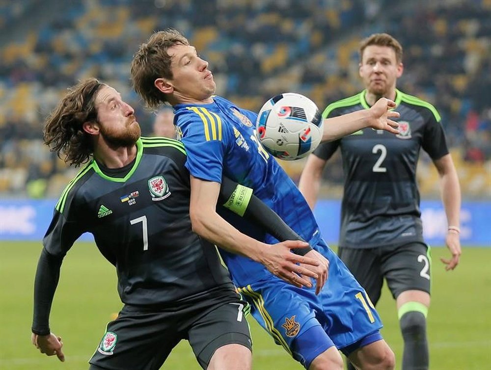 El jugador George Williams (i) de Gales disputa el balón con Denys Harmash (c) de Ucrania. EFE
