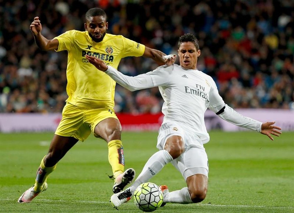 El defensa del Real Madrid Varane (d) lucha por el balón con el delantero Cédric Bakambu, del Villarreal, durante el partido de Liga que se disputa en el Bernabéu. EFE