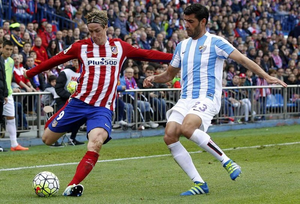 El delantero del Atlético de Madrid Fernando Torres (i) y el defensa del Málaga Miguel Torres durante el partido de la trigésimo quinta jornada de la Liga que disputan en el estadio Vicente Calderón. EFE/Archivo