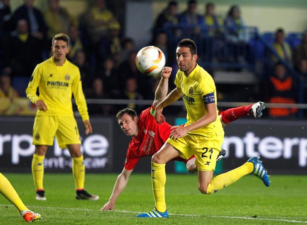 El centrocampista del Villarreal, Bruno Soriano (d), lucha el balón con el brasileño James Milner, del Liverpool, durante el partido de ida de semifinales de la Liga Europa que se juega hoy en el estadio de El Madrigal, en Villlarreal. EFE