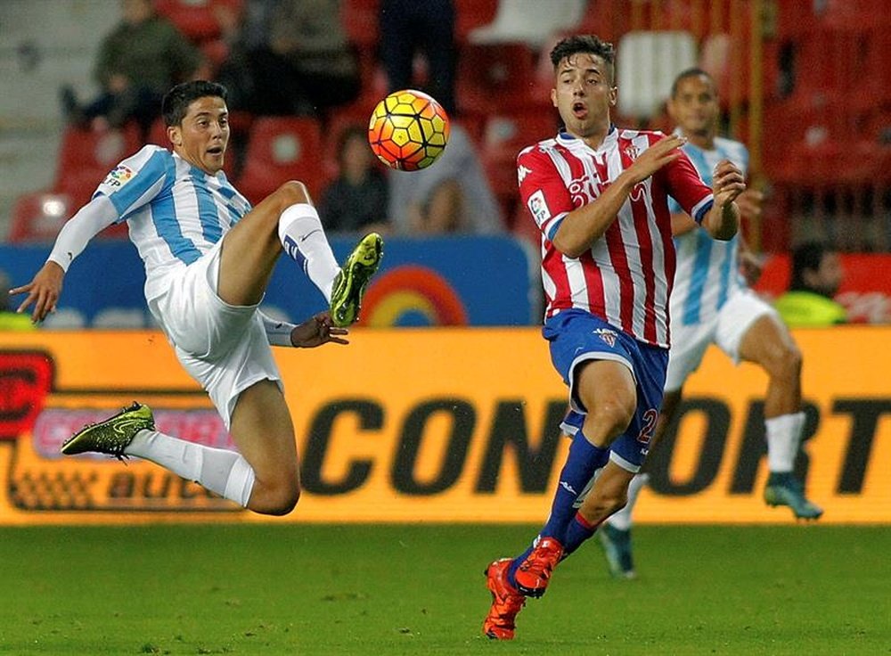 El centrocampista del Sporting Jony Rodríguez (d) disputa un balón con el jugador del Málaga Pablo Fornals. EFE/Archivo