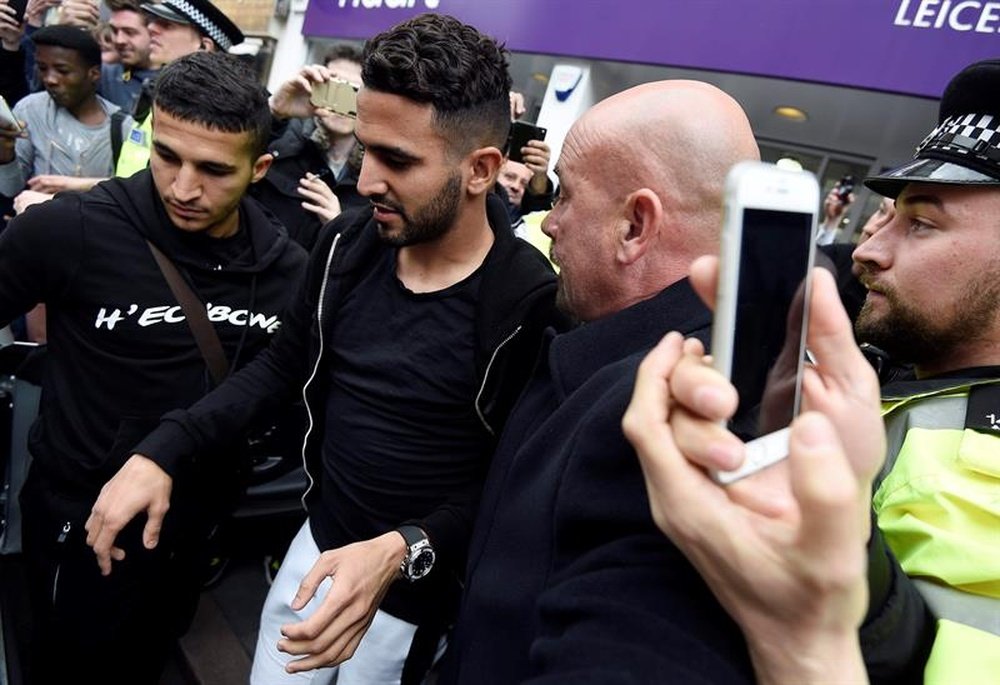El jugador del Leicester Riyad Mahrez (c) sale del restaurante donde su equipo celebra su primer título de la Premier League, en Leicester, Reino Unido, hace dos días. EFE