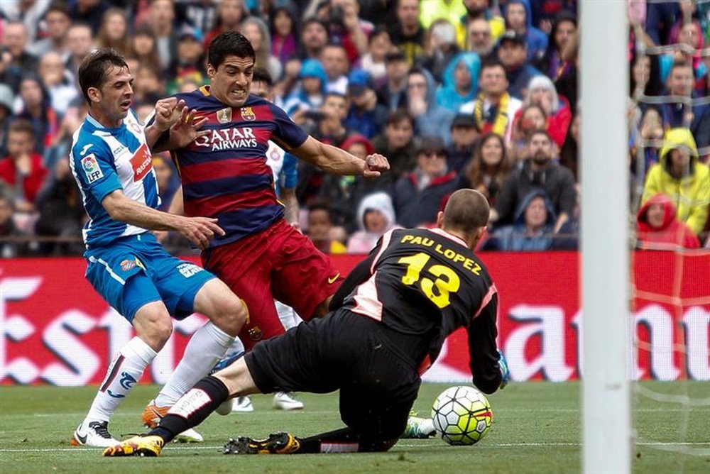 El delantero uruguayo del FC Barcelona Luís Suárez (c) lucha con el centrocampista del RCD Espanyol Victor Sánchez (i) durante el partido de la trigésimo séptima jornada de la Liga de Primera División que se jugó en el Camp Nou. EFE
