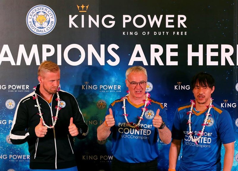 Los jugadores del Leicester City de Inglaterra Kasper Schmeichel (i) y Shinji Okazaki (d) junto a su entrenador, Claudio Ranieri (c), a su llegada al aeropuerto Suvarnabhumi de Bangkok hoy, 18 de mayo de 2016. EFE