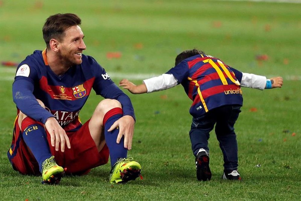 El delantero del FC Barcelona Leo Messi (i) celebra con su hijo tras vencer al Sevilla en la final de la Copa del Rey disputada anoche en el estadio Vicente Calderón, en Madrid. EFE
