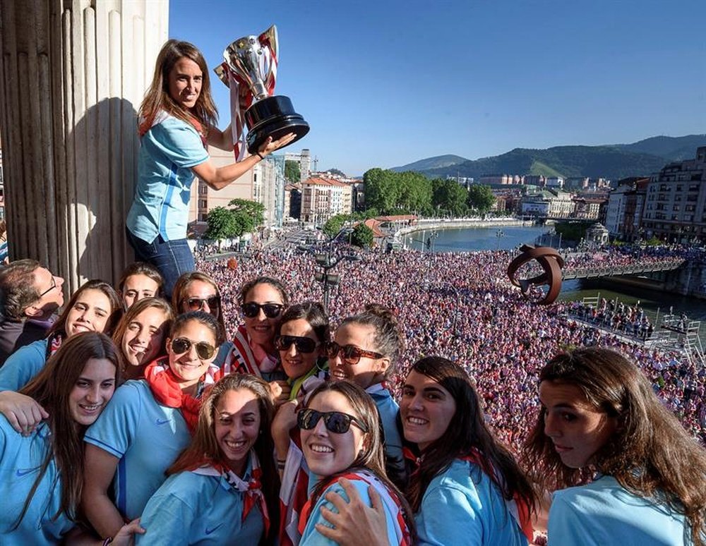 Iraia Iturregi, capitana del Athletic Club muestra la copa que acredita al equipo vencedor de la Liga de fútbol femenina, junto a sus compañeras en el balcón del Ayuntamiento de Bilbao ayer. EFE