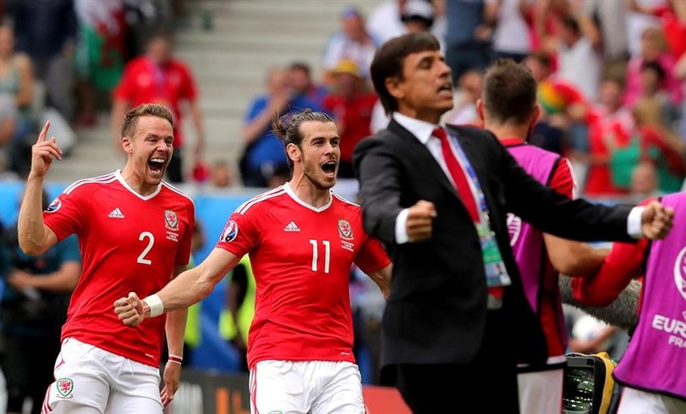 El delantero galés Gareth Bale celebra su gol perseguido por su compañero Chris Gunter, mientras que el seleccionador Chris Coleman  también muestra su alegría con la grada. EFE/EPA