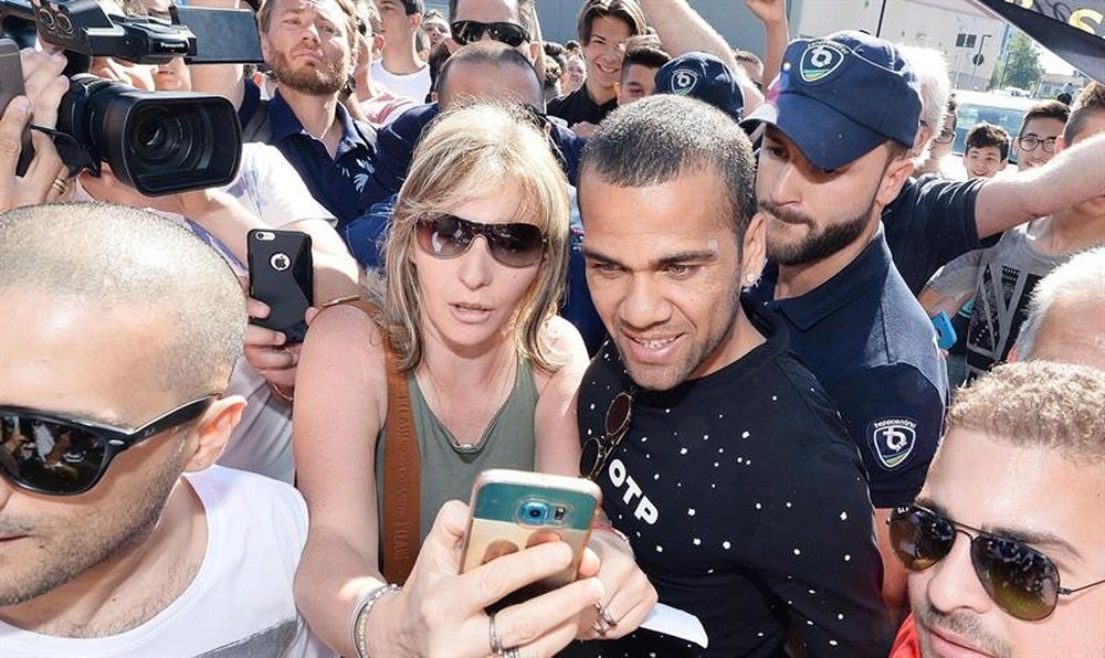 El nuevo futbolista brasileño del Juventus Dani Alves (c) posa con los fans que le aguardaban a su llegada al centro J Medical, donde pasó el correspondiente reconocimiento médico, en Turín, Italia, ayer. EFE