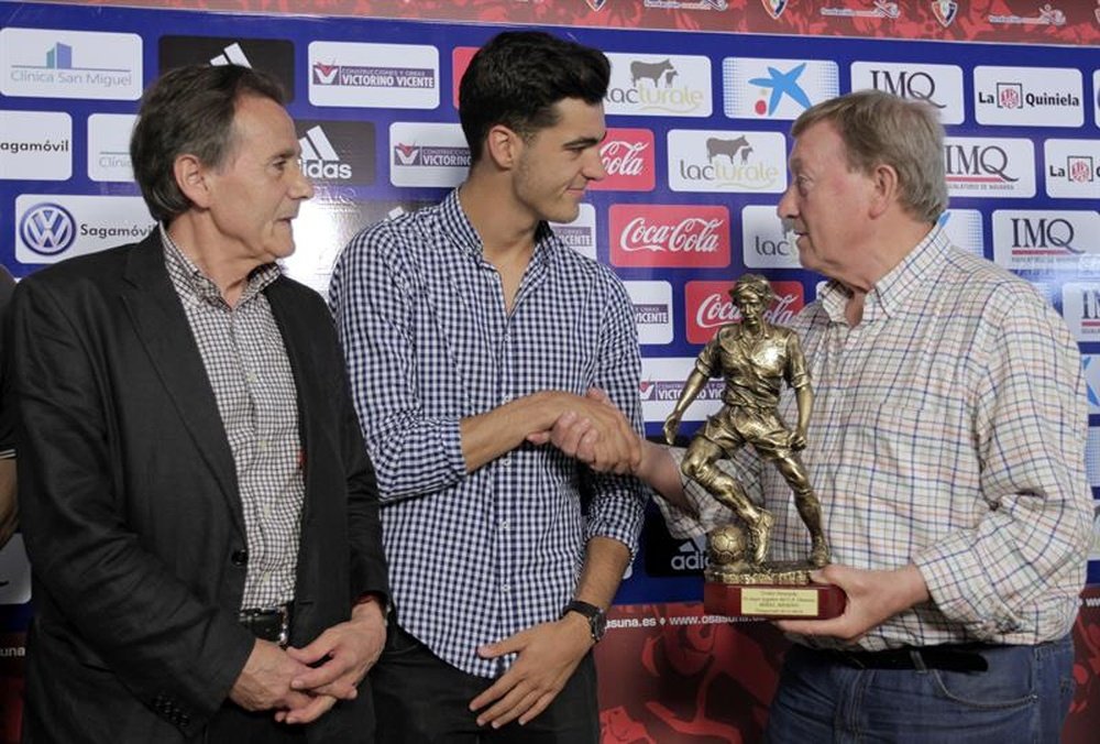 Merino receives a trophy. AFP