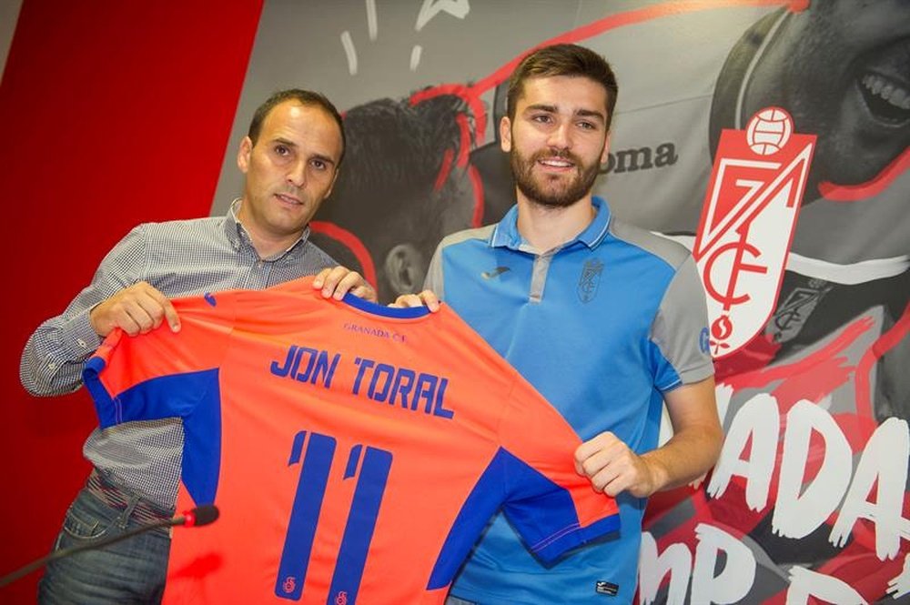 El director deportivo del club nazarí, Javier Torralbo (i), sujeta junto al centrocampista Jon Toral (d), la camiseta con la que jugará la próxima temporada. EFE