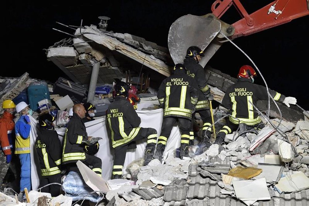 Los bomberos recuperan el cadáver de una víctima de entre los escombros de un edificio derrumbado en Amatrice, centro de Italia, hoy, 25 de agosto de 2016. EFE