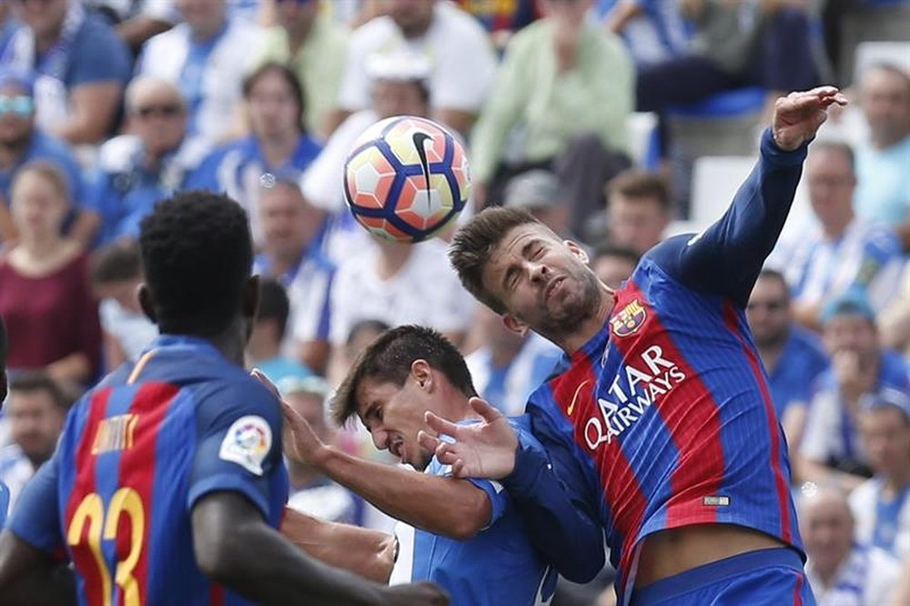 El central del FC Barcelona Gerard Piqué,d, despeja un balón durante el partido de La Liga que el FC Barcelona y el Leganés disputaron en el estadio de Butarque. EFE