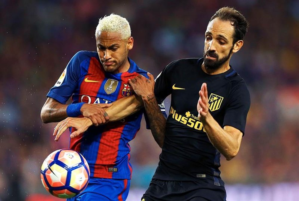 El delantero brasileño del F. C. Barcelona, Neymar (i), disputa el balón ante el defensa del Atlético de Madrid, Juanfran, durante el encuentro correspondiente a la quinta jornada de primera división, que han disputado en el estadio del Camp Nou, en Barcelona. EFE