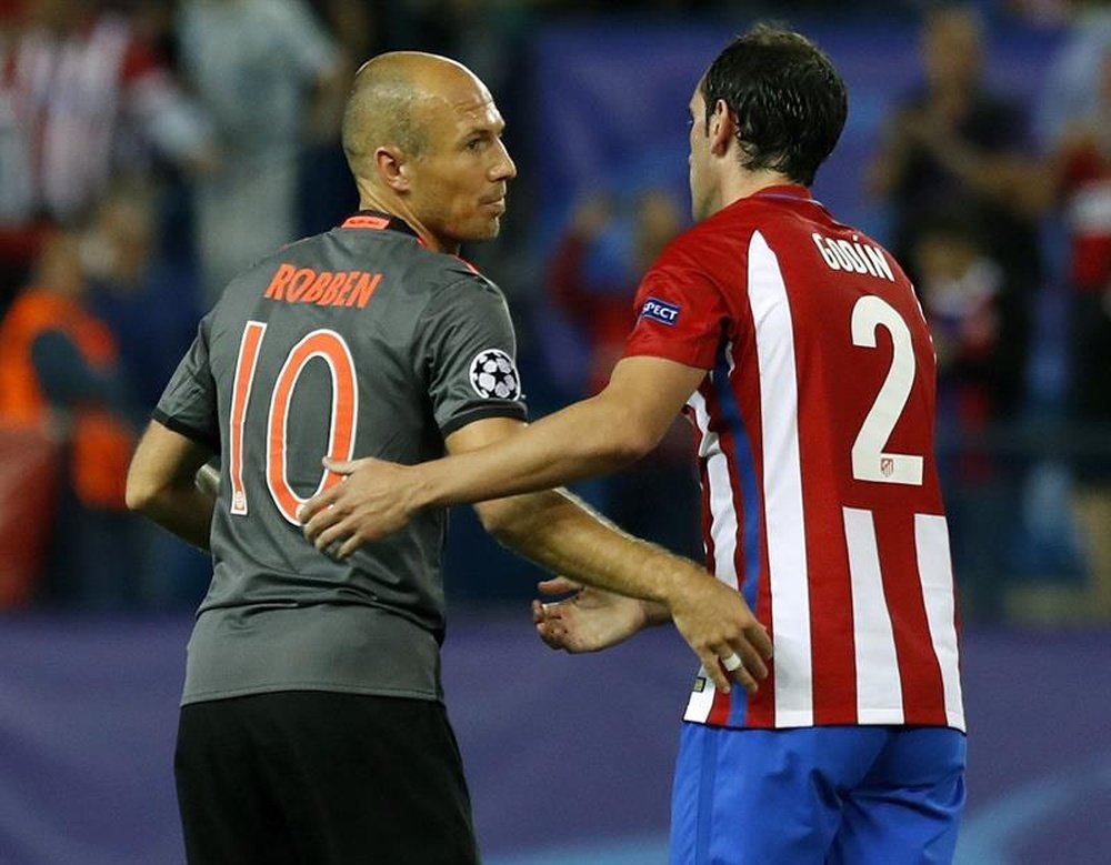 Godin (R) shakes the hand of Arjen Robben (L) during the Atletico Madrid-Bayern Munich match. AFP