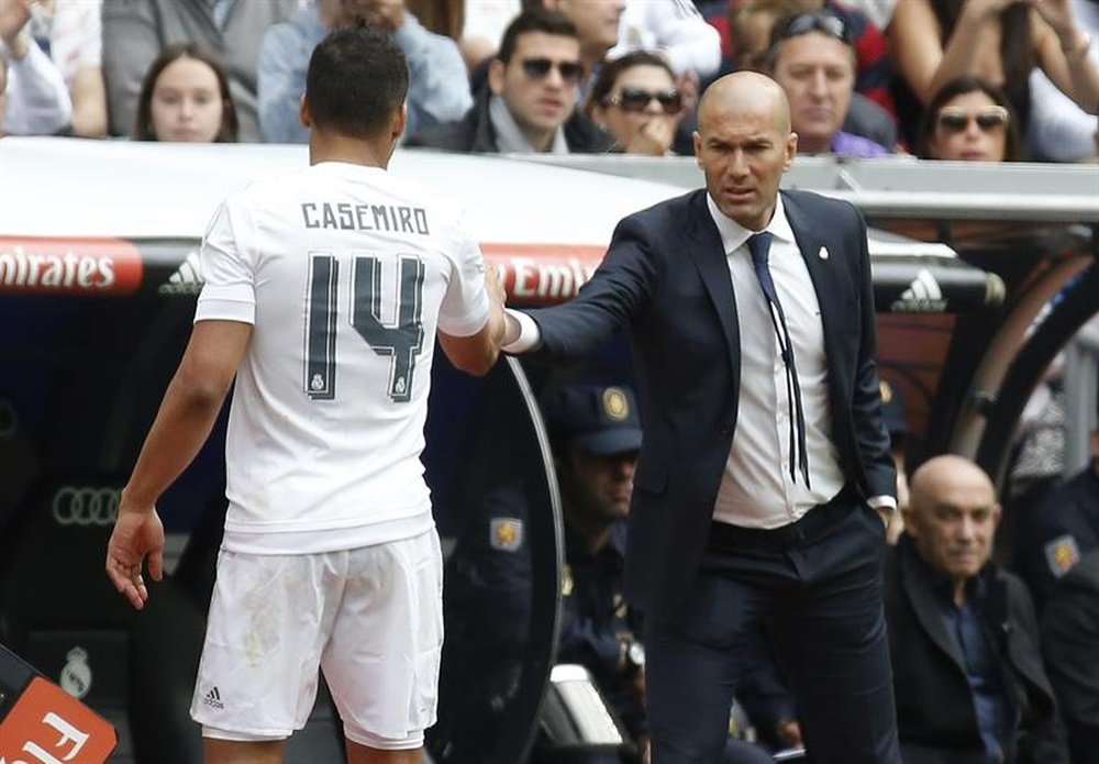 El entrenador del Real Madrid Zinedine Zidane (d) saluda al centrocampista Casemiro en el estadio Santiago Bernabéu. EFE/Archivo