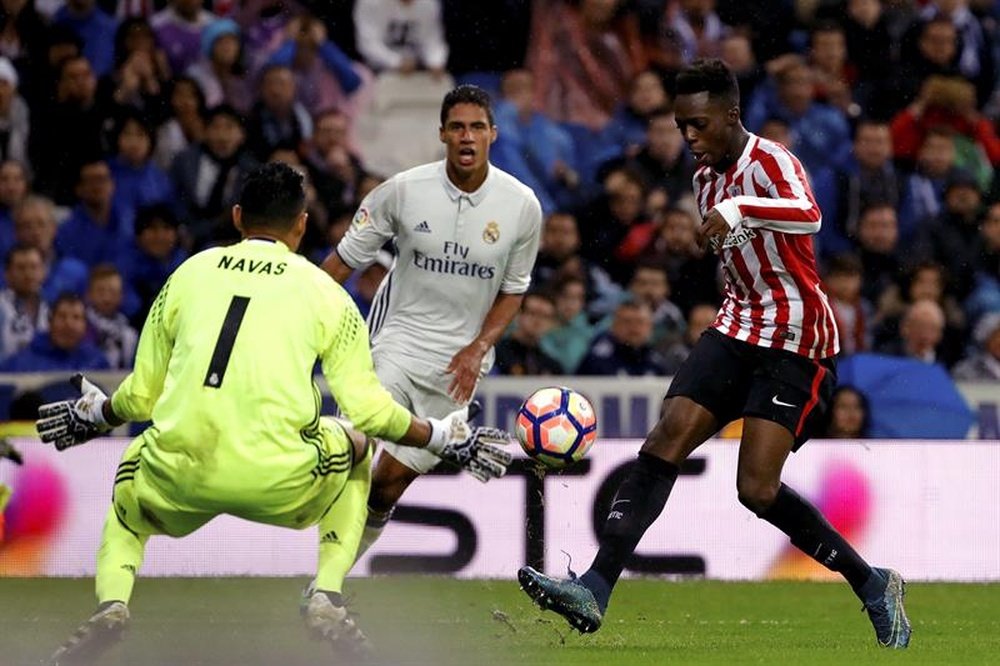 El jugador del Athletic de Bilbao Iñaki Williams (d) trata de superar la salida de Keylor Navas (i), portero del Real Madrid, durante el partido de la novena jornada de Liga en Primera División disputado en el estadio Santiago Bernabéu, en Madrid. EFE
