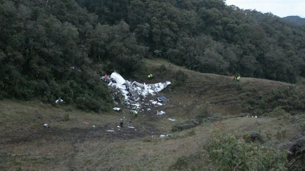 Un grupo de campesinos observa hoy, martes 29 de noviembre de 2016, los restos del avión accidentado en el municipio de La Ceja, departamento de Antioquia (Colombia). EFE