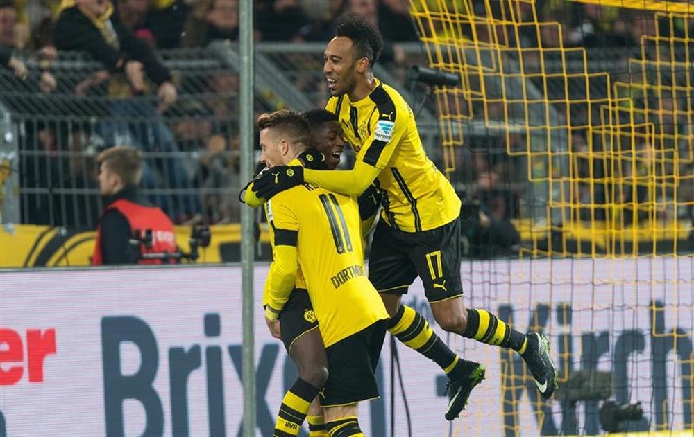 El jugador del Dortmund Ousmane Dembele (c) celebra con sus compañeros de equipo Pierre-Emerick Aubameyang (d) y Marco Reus (i) tras marcar el 3-1 ante el Moenchengladbach en Dortmund, Alemania. EFE