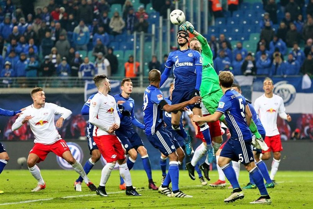 El portero del Schalke Ralf Faehrmann (de verde) trata de despejar una acción a balón parado en el partido de la Bundesliga que han jugado RasenBallsport Leipzig y FC Schalke 04 en Leipzig, Alemania. EFE/EPA