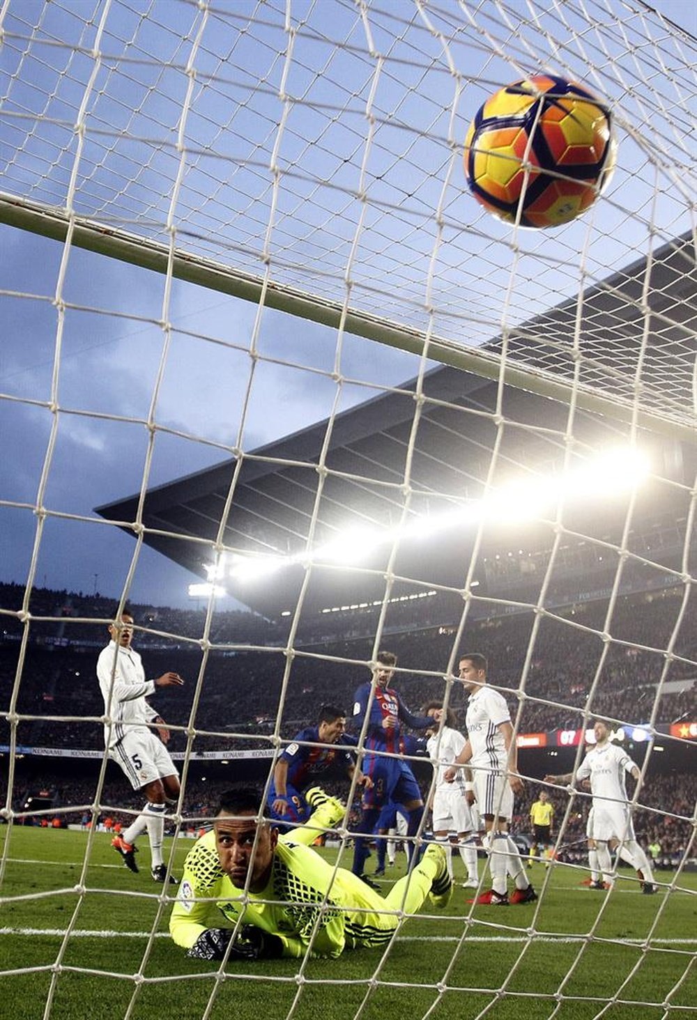 El delantero uruguayo del FC Barcelona, Luis Suárez (c) anota el gol de cabeza frente al portero costarricense Keylor Navas (abajo) del Real Madrid durante el partido de la decimocuarta jornada de Liga que disputaron en el Camp Nou de Barcelona. EFE