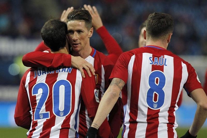 El delantero del Atlético de Madrid Fernando Torres (c) celebra con sus compañeros Juanfran (i) y Saúl Ñíguez el gol marcado ante el Guijuelo, el cuarto del equipo, durante el partido de vuelta de los dieciseisavos de final de la Copa del Rey que se disputó en el estadio Vicente Calderón, en Madrid. EFE