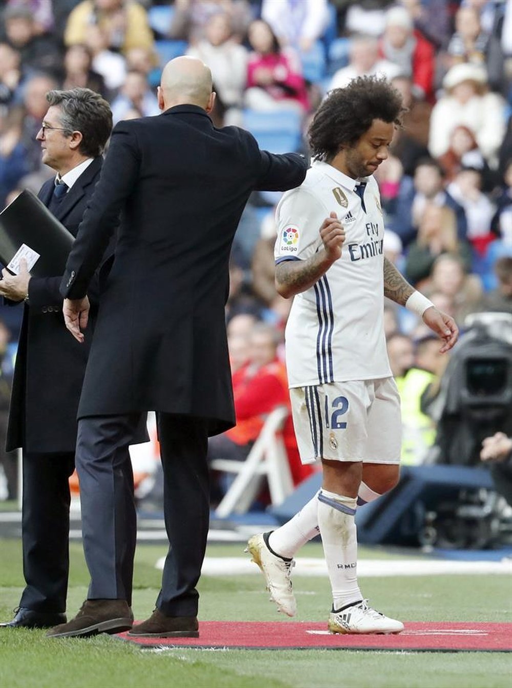 El defensa brasileño del Real Madrid Marcelo Vieira (d) se retira lesionado, durante el partido frente al Málaga de la décima novena jornada de la Liga de Primera División que se jugó en el Santiago Bernabéu, en Madrid. EFE