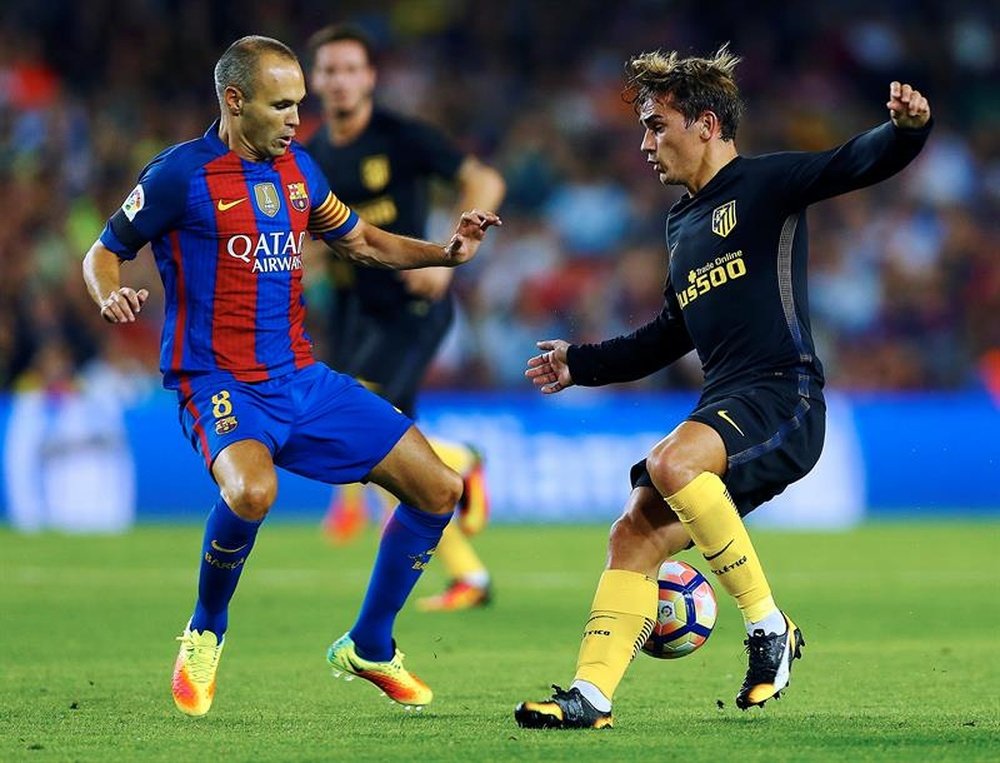 Barcelona's Andres Iniesta (left) vying for the ball with Atletico's Antoine Griezmann. EFE