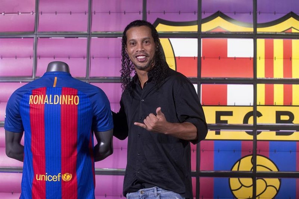 El exjugador del FC Barcelona Ronaldinho, posa hoy para los medios de comunicación, durante su presentación como nuevo embajador del FC Barcelona, para el que hará funciones de representación en actos oficiales. EFE