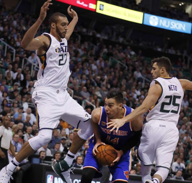 El jugador de Knicks Willy Hernangomez (c) ante Rudy Gobert (i) y Raúl Neto (d) de Jazz, durante un partido entre Knicks y Jazz por la NBA, en la Energy Solutions Arena de Salt Lake City, Utah (EE.UU.). EFE