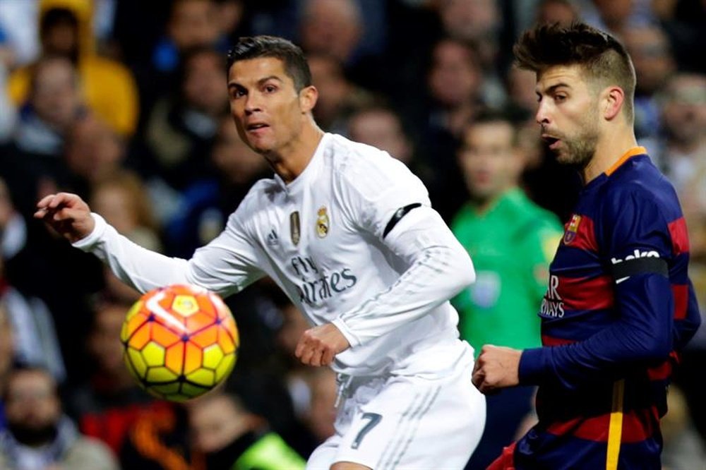 L'attaquant portugais du Real Madrid, Cristiano Ronaldo à la lutte avec Piqué du FC Barcelone. EFE