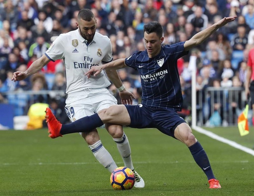 L'attaquant du Real Madrid, Benzema, à la lutte contre Juanpi, milieu de Malaga en Liga. EFE
