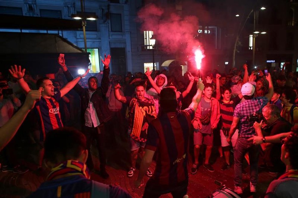 La afcición del FC Barcelona celebra el título de la Copa del Rey en la plaza de Canaletas, en Barcelona, tras la final que ha ganado el equipo blaugrana al Deportivo Alavés esta noche en el estadio Vicente Calderón. EFE/Alejandro García