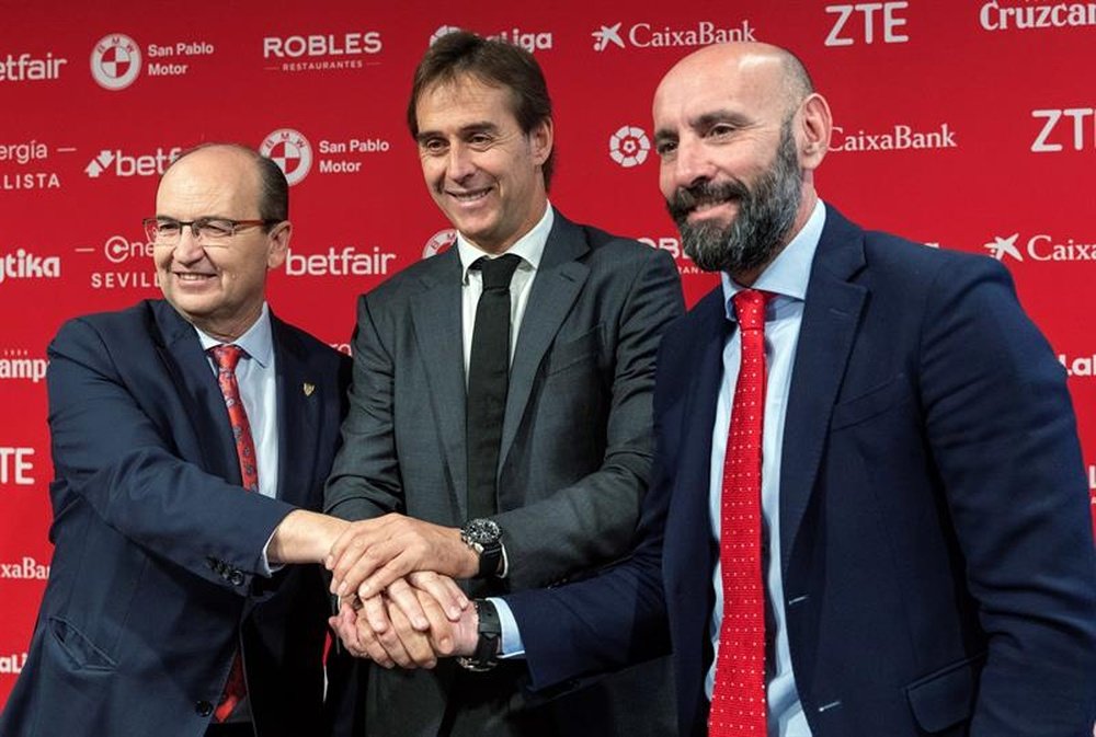 El presidente del Sevilla FC, José Castro (i), y el director deportivo del club, Ramón Rodríguez ?Monchi? (d), unen sus manos con el técnico Julen Lopetegui durante su presentación como nuevo entrenador del equipo sevillista. EFE/Archivo