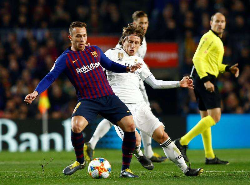 Arthur Melo y Luka Modric pelean por un balón en un FC Barcelona-Real Madrid.