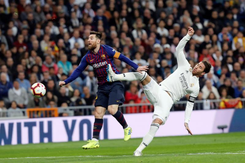Leo Messi y Sergio Ramos pelean por un balón durante el Clásico.