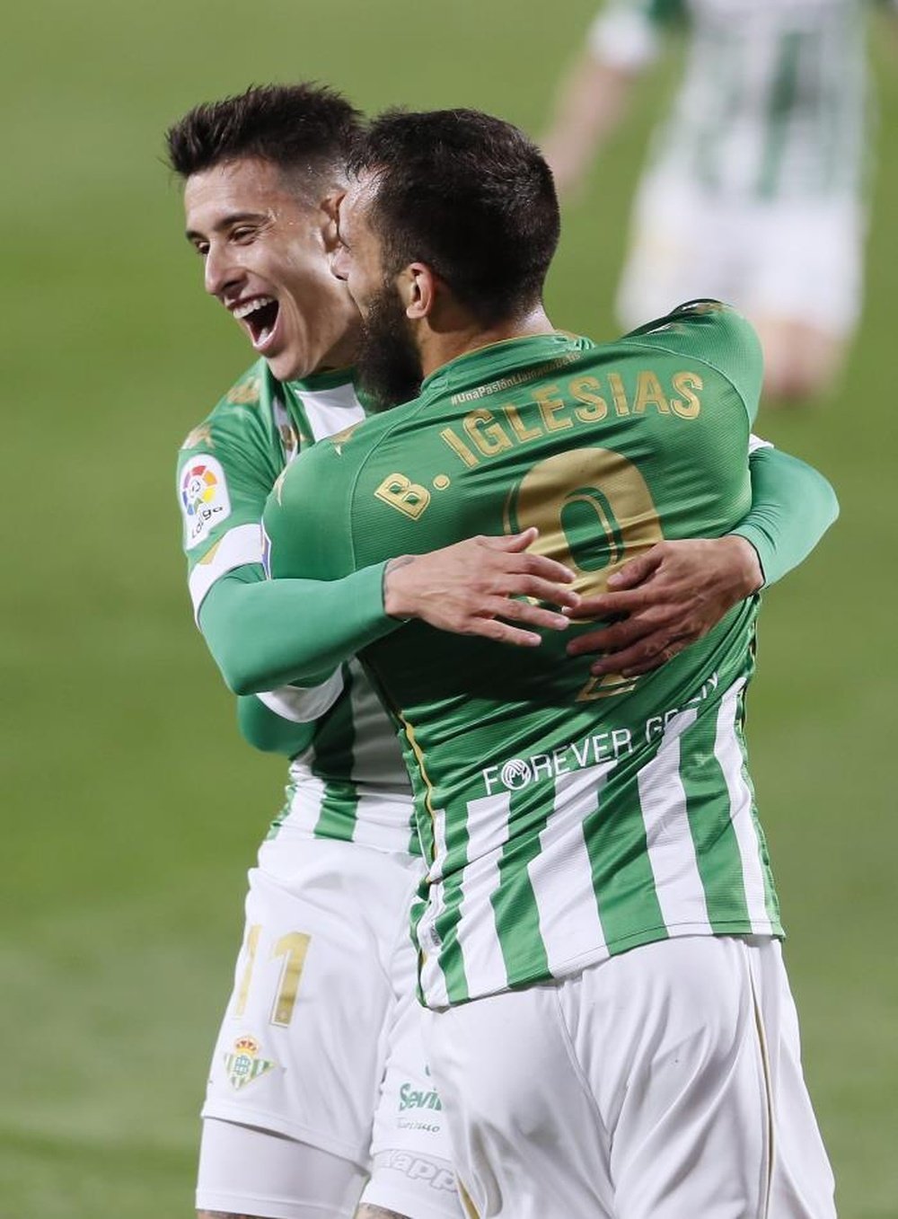 Los jugadores del Betis, Borja Iglesias (d) y Cristián Tello, celebran el primer gol del equipo bético durante el encuentro correspondiente a la jornada 21 de primera división disputado este lunes frente a Osasuna en el estadio Benito Villamarín, en Sevilla. EFE/Jose Manuel Vidal