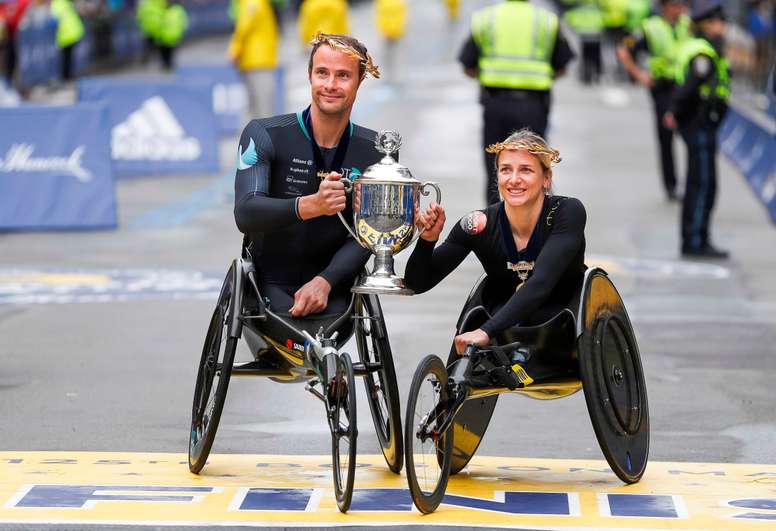 Marcel Hug (izq.) Y Manuela Schar de Suiza posan en la línea de meta con el trofeo después de ganar respectivamente las carreras en silla de ruedas masculina y femenina del 125 ° Maratón de Boston .EFE/CJ Gunther