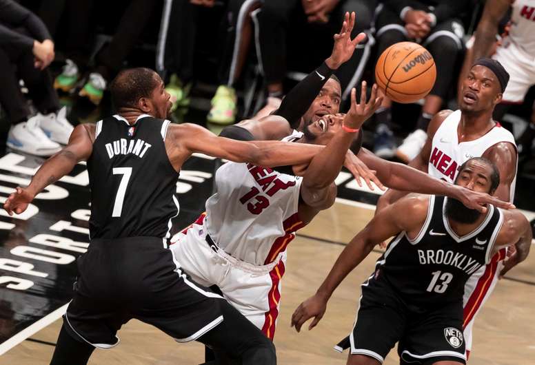 El jugador de los Heat de Miami, Bam Adebayo (C) y el de los Nets de Brooklyn, Kevin Durant (i) luchan por un rebote durante la segunda mitad del partido de baloncesto de la NBA. EFE / EPA / JUSTIN LANE SHUTTERSTOCK OUT