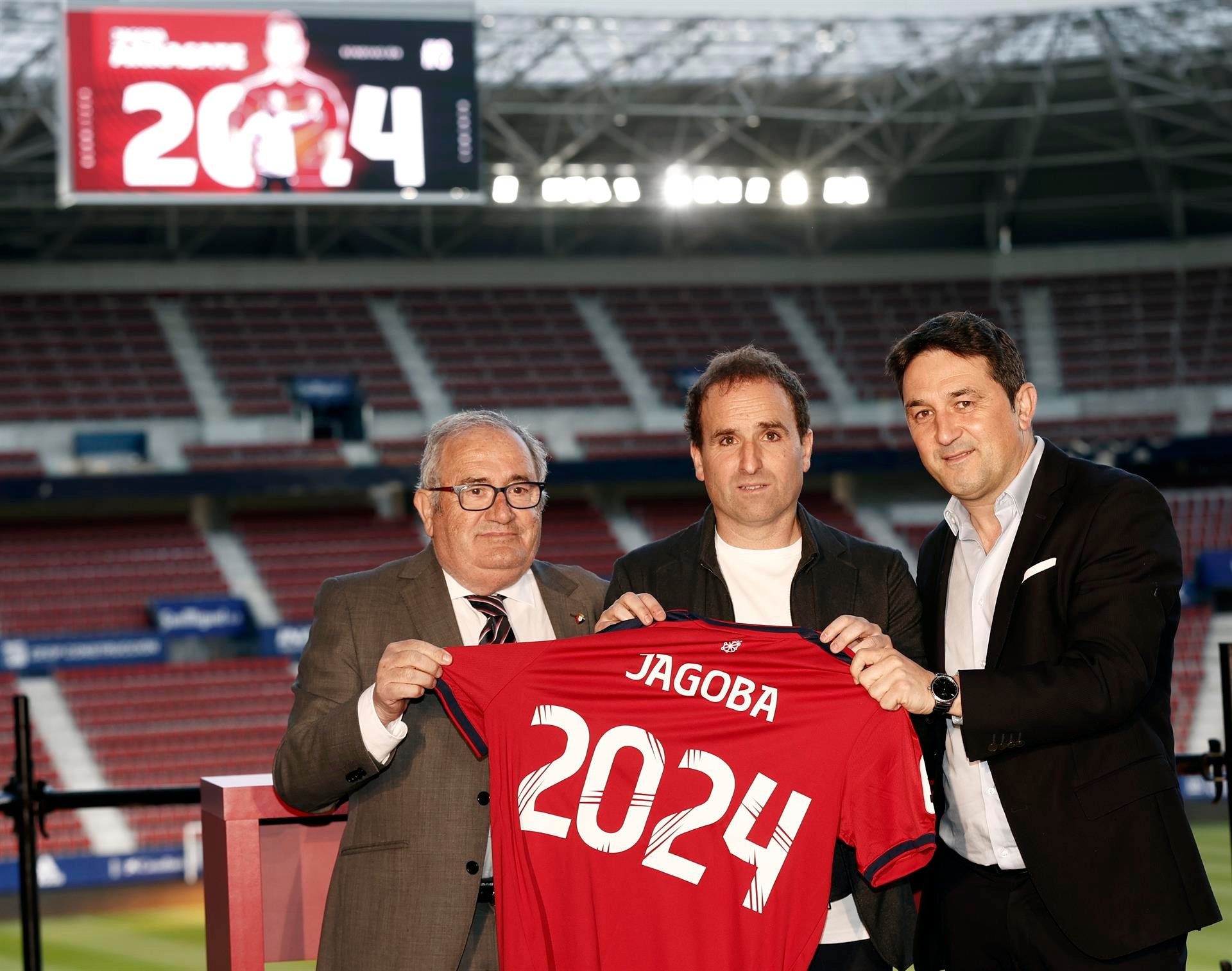 El entrenador de Osasuna, Jagoba Arrasate (c), el presidente del club, Luis Sabalza (i), y el director deportivo, Braulio Vazquez (d), posan con la camiseta del entrenador rojillo después de firmar esta semana en el Estadio de El Sadar la renovación de su contrato por otros dos años mas. EFE/ Jesús Diges