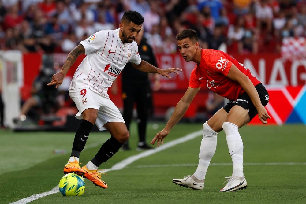 El delantero del Sevilla Jesús Corona `Tecatito` (i) juega un balón ante Martin Valjent, del Mallorca, durante el partido de Liga en Primera División en el estadio Ramón Sánchez-Pizjuán, en Sevilla. EFE/Julio Muñoz