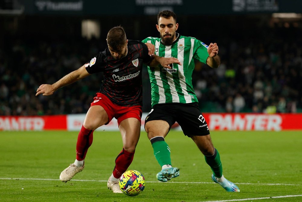 El delantero del Real Betis Borja Iglesias (d) disputa el balón con Yeray Álvarez, del Athletic Club de Bilbao, durante el partido de la jornada 15 de LaLiga entre el Real Betis y el Athletic Club de Bilbao, este jueves en el estadio Benito Villamarín, en Sevilla. EFE/ Julio Muñoz