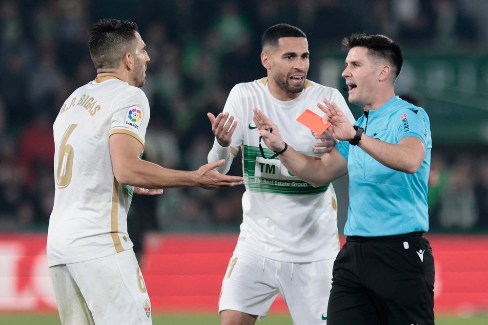 Ortiz Arias, árbitro del partido, enseñatarjeta roja al defensa del Elche Pedro Bigas (i). EFE/ Ana Escobar