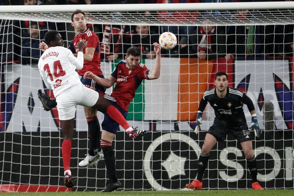 El defensa francés del Sevilla Tanguy Nianzou (i) intenta un remate ante varios rivales de Osasuna durante el partido de cuartos de final de la Copa del Rey en el estadio de El Sadar, en Pamplona. EFE/Jesús Diges.